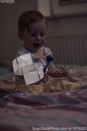 Image of cute little one year old baby and making first steps in bed