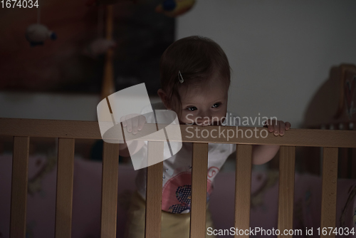 Image of cute little one year old baby and making first steps in bed