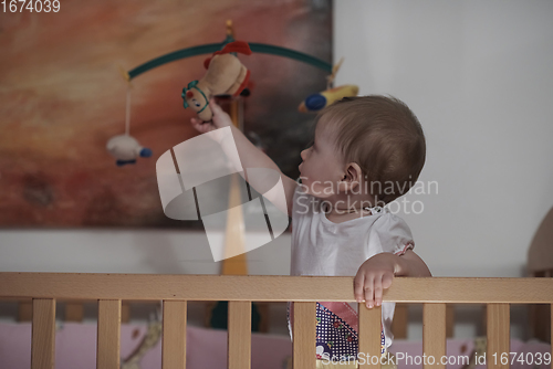 Image of cute little one year old baby and making first steps in bed