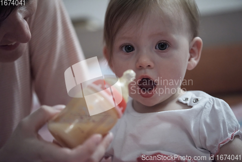 Image of little baby drinking juice from bottle