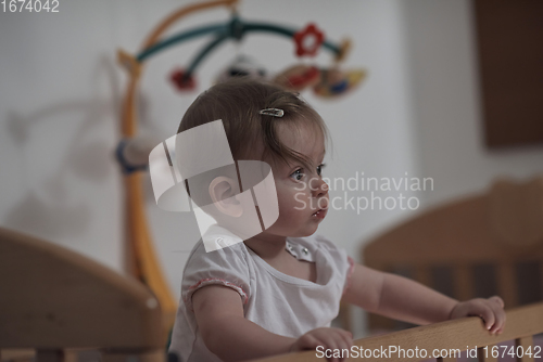 Image of cute little one year old baby and making first steps in bed