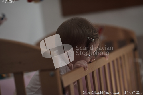 Image of cute little one year old baby and making first steps in bed