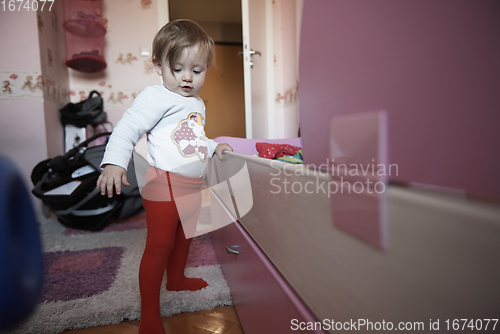 Image of cute little one year old baby and making first steps