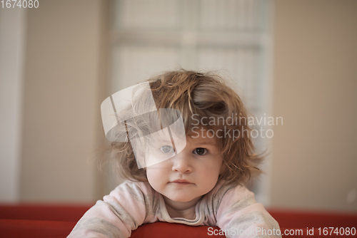 Image of little baby girl with strange hairstyle and curlers