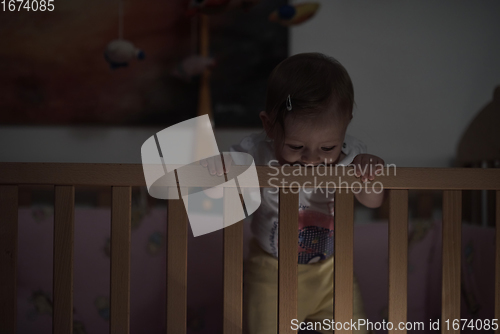 Image of cute little one year old baby and making first steps in bed