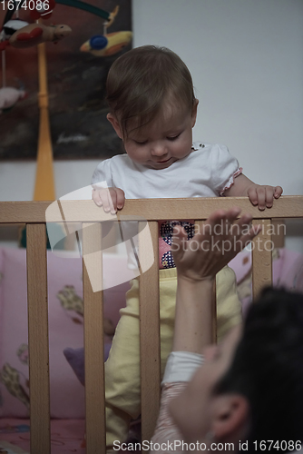 Image of cute little one year old baby and making first steps in bed