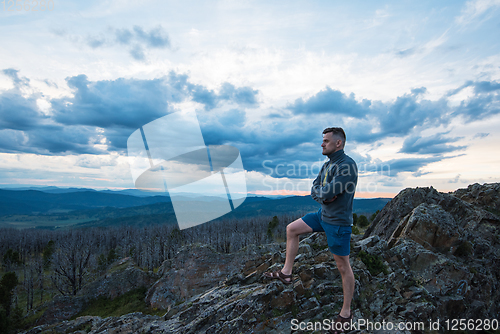 Image of Man standing on top of cliff