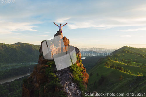 Image of Man standing on top of cliff