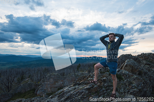 Image of Man standing on top of cliff