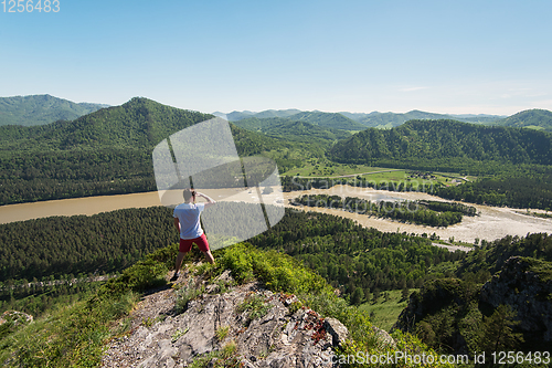 Image of Man standing on top of cliff