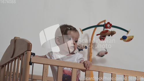 Image of cute little one year old baby and making first steps in bed