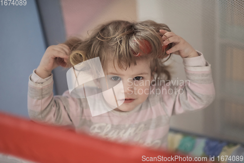 Image of little baby girl with strange hairstyle and curlers