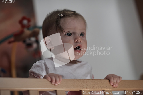 Image of cute little one year old baby and making first steps in bed