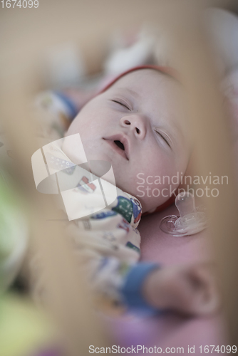 Image of newborn baby sleeping at home in bed