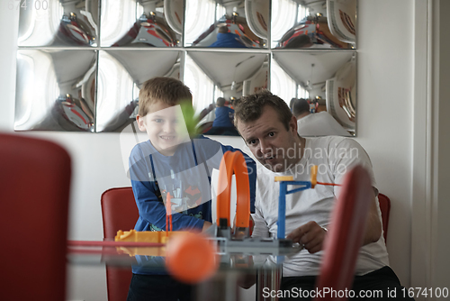 Image of Father and children playing car toy game