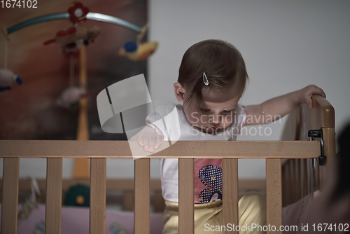 Image of cute little one year old baby and making first steps in bed