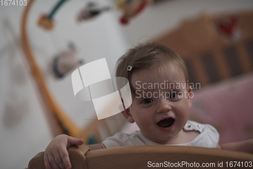 Image of cute little one year old baby and making first steps in bed