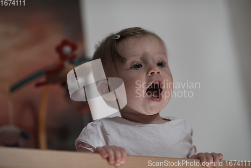 Image of cute little one year old baby and making first steps in bed