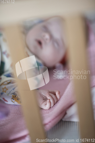 Image of newborn baby sleeping at home in bed