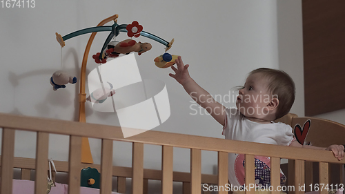 Image of cute little one year old baby and making first steps in bed