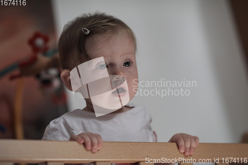 Image of cute little one year old baby and making first steps in bed