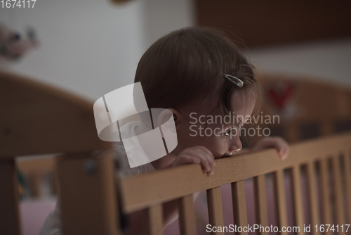 Image of cute little one year old baby and making first steps in bed