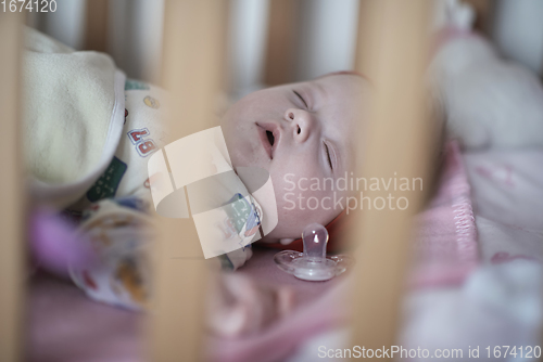 Image of newborn baby sleeping at home in bed