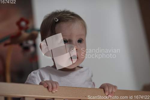 Image of cute little one year old baby and making first steps in bed