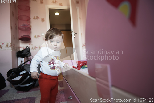 Image of cute little one year old baby and making first steps