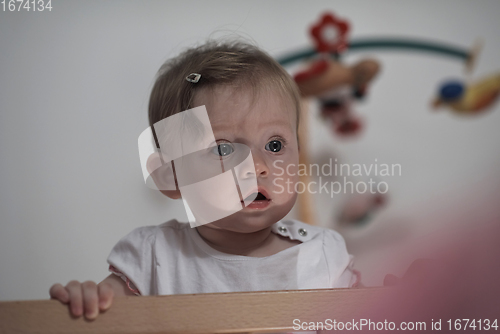 Image of cute little one year old baby and making first steps in bed