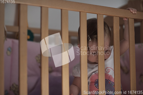 Image of cute little one year old baby and making first steps in bed