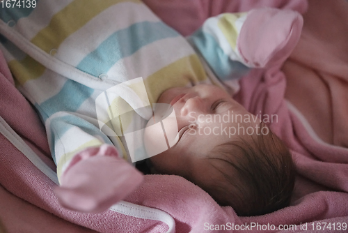 Image of newborn baby sleeping at home in bed