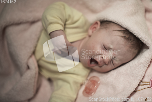 Image of newborn baby sleeping at home in bed