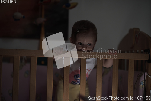 Image of cute little one year old baby and making first steps in bed