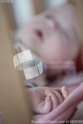 Image of newborn baby sleeping at home in bed