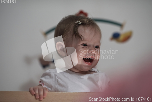 Image of cute little one year old baby and making first steps in bed