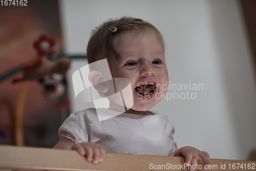 Image of cute little one year old baby and making first steps in bed