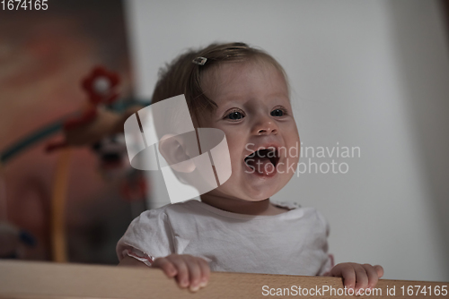 Image of cute little one year old baby and making first steps in bed