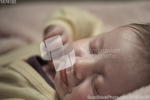 Image of newborn baby sleeping at home in bed