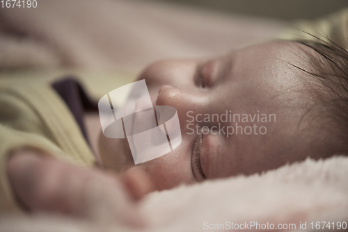 Image of newborn baby sleeping at home in bed