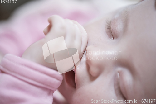 Image of newborn baby sleeping at home in bed