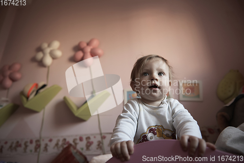 Image of cute little one year old baby and making first steps