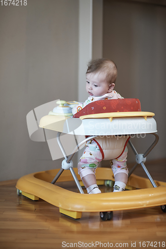 Image of baby learning to walk in walker