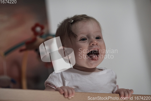 Image of cute little one year old baby and making first steps in bed
