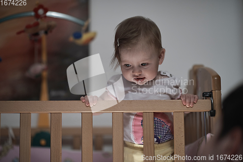 Image of cute little one year old baby and making first steps in bed