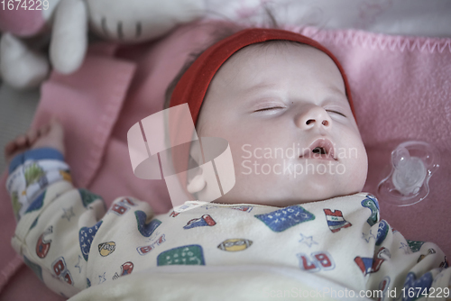 Image of newborn baby sleeping at home in bed