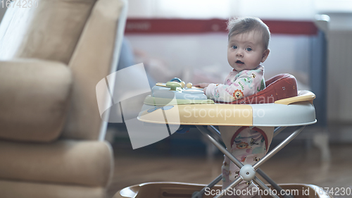 Image of baby learning to walk in walker