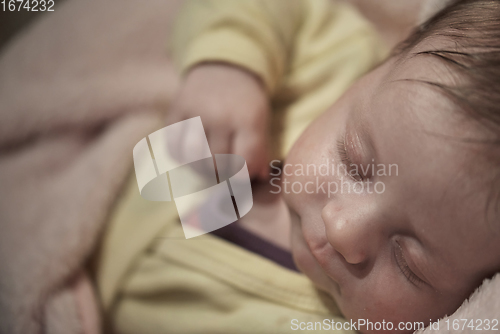 Image of newborn baby sleeping at home in bed
