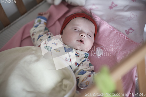 Image of newborn baby sleeping at home in bed