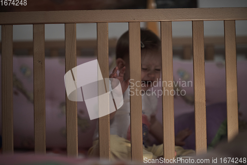 Image of cute little one year old baby and making first steps in bed